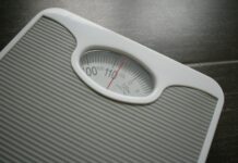 다이어트와 운동: 몸과 마음에 긍정적인 변화를 가져오는 두 가지 주축 a bathroom scale sitting on top of a wooden table