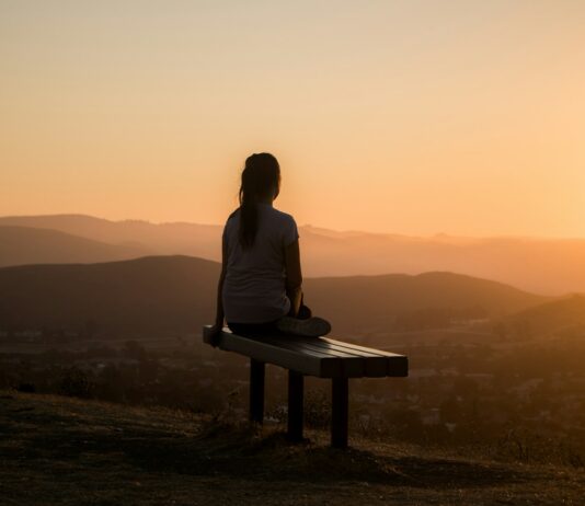 걷기의 건강상의 이점 woman sitting on bench over viewing mountain