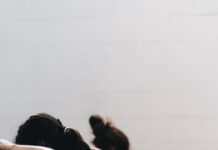 체중 감소를 위한 HIIT 운동 woman in black tank top and black leggings lying on black floor