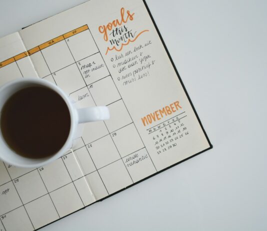 직장 내 스트레스 관리: 생산성 향상의 열쇠 white ceramic mug with coffee on top of a planner