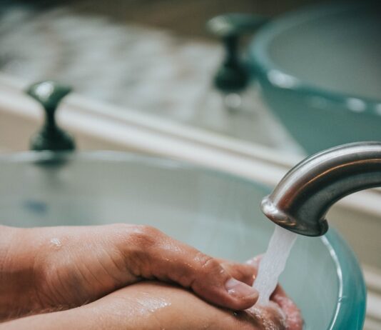 감기 걱정 없는 겨울을 위한 건강 관리 팁 person holding stainless steel faucet