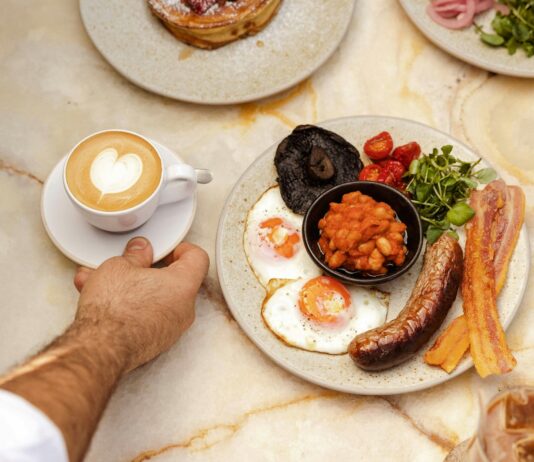 아침 루틴이 바뀌면 하루 전체의 생체 리듬이 달라지는 이유 a hand holding a plate of food