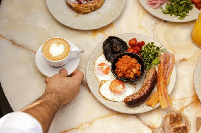 Photo by Edward Howell a hand holding a plate of food