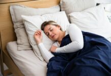 ‘꿀잠’ 위한 새로운 루틴… 수면 트렌드와 실천법 둘러보기 a woman sleeping on a bed with a blue blanket