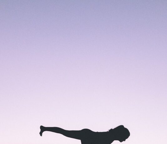 도심 속 사바사나: “운동 끝나고 잠만 자는데?” 송장 자세가 주는 휴식의 진정한 가치 silhouette photography of woman standing on right foot