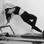 woman in black sports bra and black leggings doing yoga