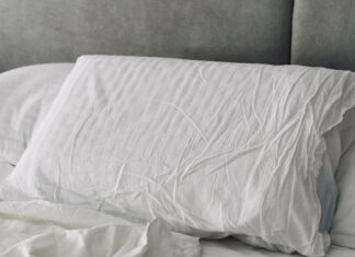 꿀잠을 위한 새로운 루틴, 수면 건강 트렌드와 실천법 A rumpled white duvet and pillows on a bed.