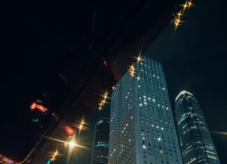 “현대인의 스트레스, 일상 속 작은 습관으로 건강하게 관리한다” Man in suit enters taxi with city skyscrapers at night