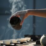 person pouring hot water on white cup