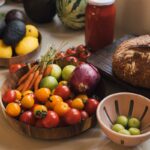 Fresh produce including tomatoes, carrots, and avocados on a counter.