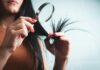 집에서 시작하는 건강한 모발 관리, 최신 트렌드와 실천 팁 Woman examining split ends of hair with magnifying glass