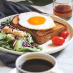 burger with egg and lettuce on white ceramic plate