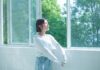정신건강, ‘작은 습관’에서 시작한다… 일상에서 실천하는 마음 건강법 woman in white long sleeve shirt and blue denim jeans standing by the window