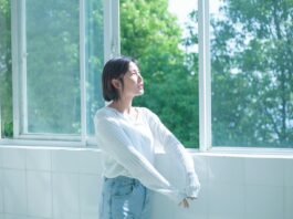 정신건강, ‘작은 습관’에서 시작한다… 일상에서 실천하는 마음 건강법 woman in white long sleeve shirt and blue denim jeans standing by the window