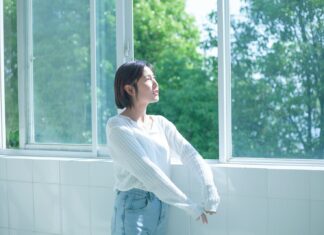 정신건강, ‘작은 습관’에서 시작한다… 일상에서 실천하는 마음 건강법 woman in white long sleeve shirt and blue denim jeans standing by the window