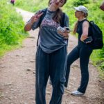 Young woman makes peace sign on a forest trail