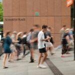 나만의 건강 루틴 만들기, ‘마이크로 운동’이 답이다 A crowd of people walking down a street next to a tall building